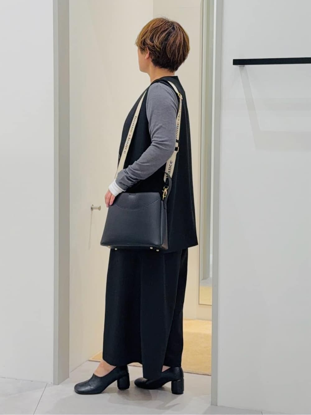 ブラック系のベスト、ブラック系のサロペット/オーバーオール、グレー系のTシャツ/カットソーを着用したレディースの春コーディネートの2枚目の写真