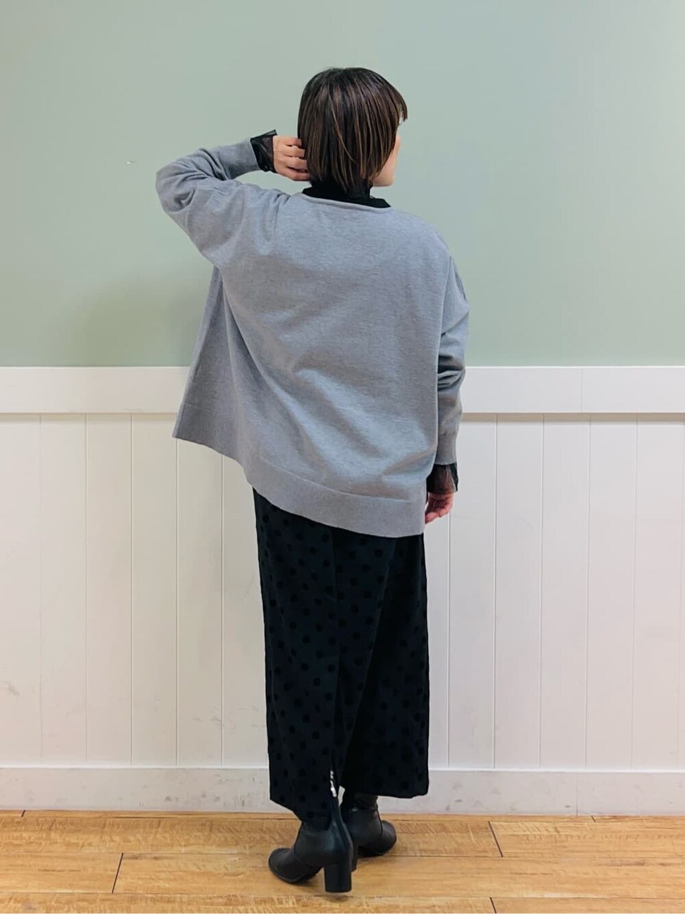 グレー系のニット/セーター、ブラック系のTシャツ/カットソー、グレー系のスカートを着用したレディースの冬コーディネートの3枚目の写真