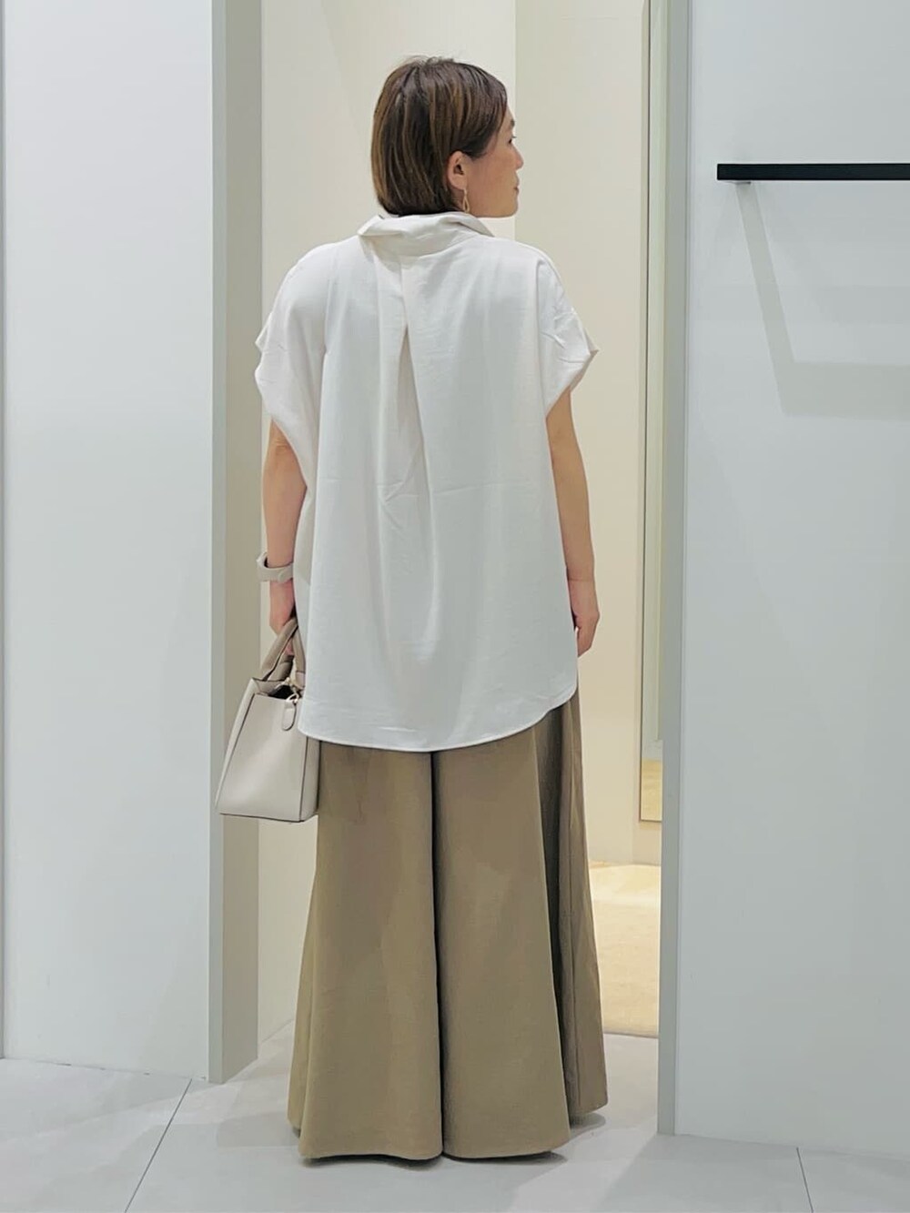 ホワイト系のシャツ/ブラウス、ベージュ系のその他パンツ、ホワイト系のショルダーバッグを着用したレディースの秋コーディネートの3枚目の写真
