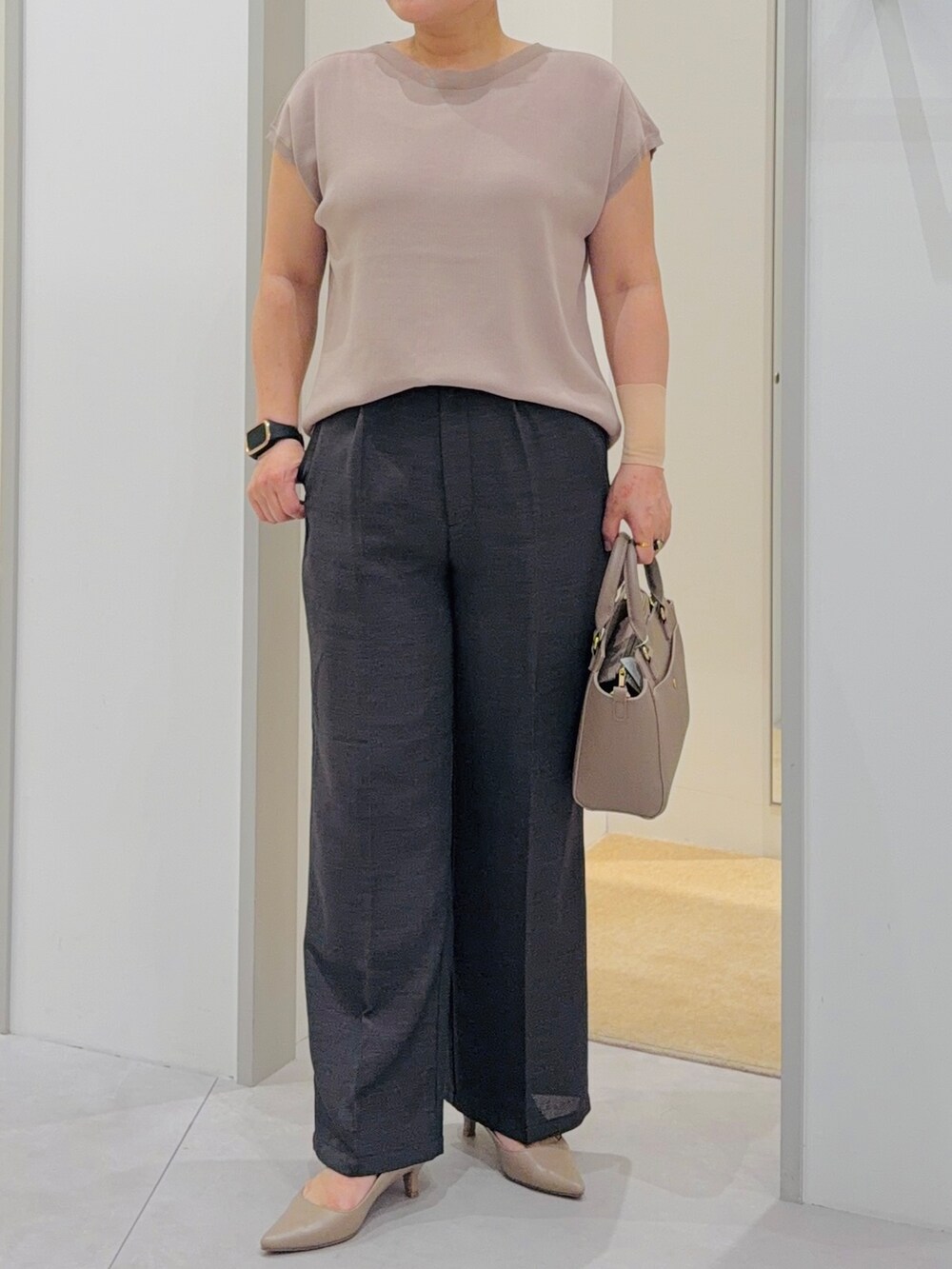 ベージュ系のニット/セーター、ブラック系のその他パンツ、ブラウン系のトートバッグを着用したレディースの夏コーディネートの5枚目の写真