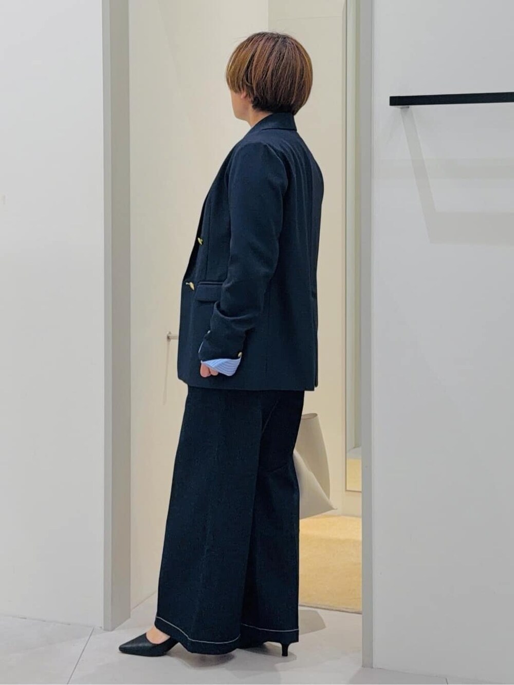 ブルー系のデニムパンツ、ホワイト系のTシャツ/カットソー、ホワイト系のトートバッグを着用したレディースの春コーディネートの2枚目の写真