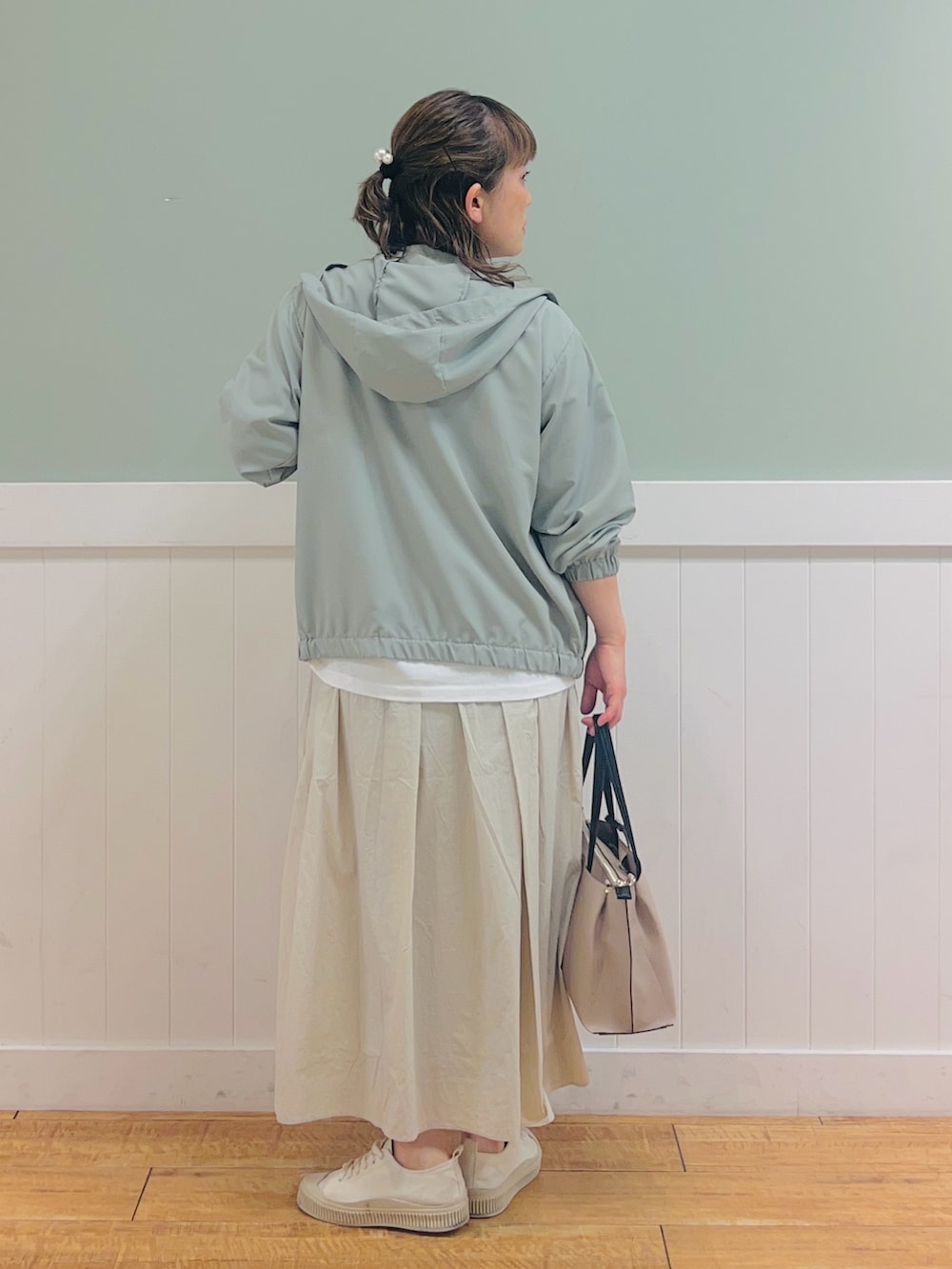 ホワイト系のTシャツ/カットソー、グリーン系のブルゾン、ベージュ系のスカートを着用したレディースの春コーディネートの2枚目の写真