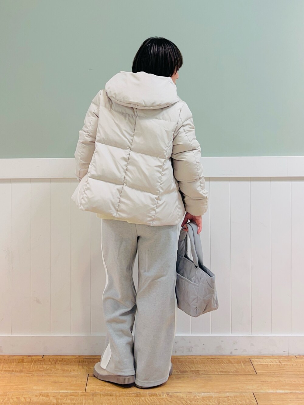 ベージュ系のダウンジャケット/コート、ホワイト系のニット/セーター、グレー系のその他パンツを着用したレディースの冬コーディネートの4枚目の写真