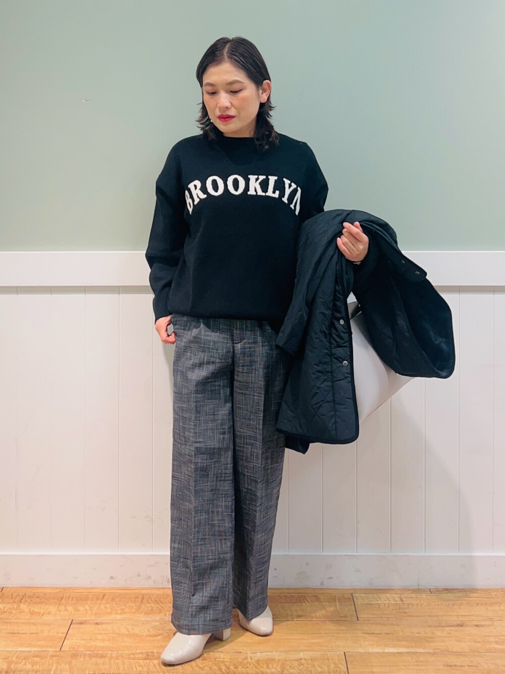 ブラック系のニット/セーター、ブラック系のその他アウター、グレー系のトートバッグを着用したレディースの冬コーディネートの3枚目の写真