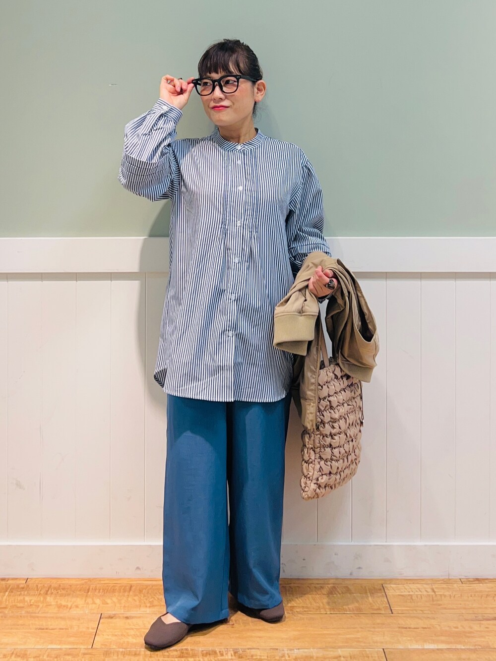 ブルー系のシャツ/ブラウス、ブラウン系のベスト、ベージュ系のバッグを着用したレディースの秋コーディネートの4枚目の写真