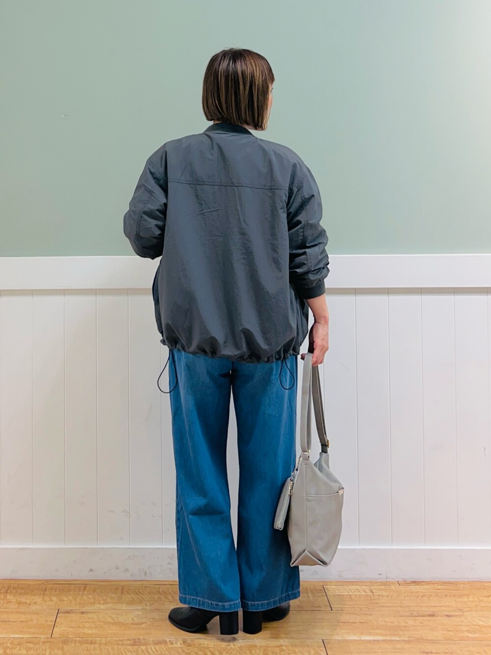 グレー系のブルゾン、ピンク系のニット/セーター、グレー系のショルダーバッグを着用したレディースの秋コーディネートの4枚目の写真