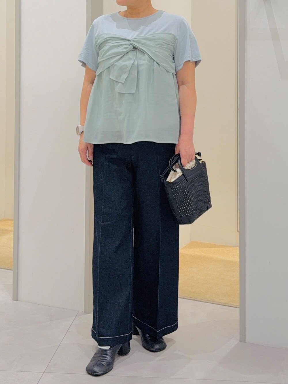 グリーン系のTシャツ/カットソー、ブラック系のデニムパンツ、グリーン系のショルダーバッグを着用したレディースの夏コーディネートの5枚目の写真