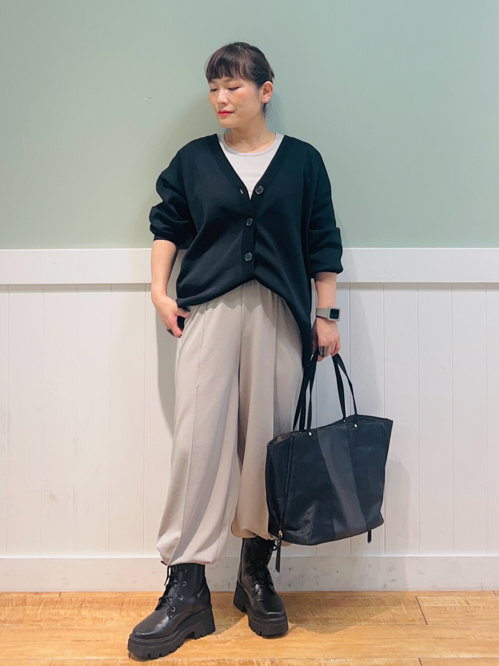 ブラック系のトートバッグ、グレー系のタンクトップ、ブラック系のカーディガン/ボレロを着用したレディースの冬コーディネートの2枚目の写真