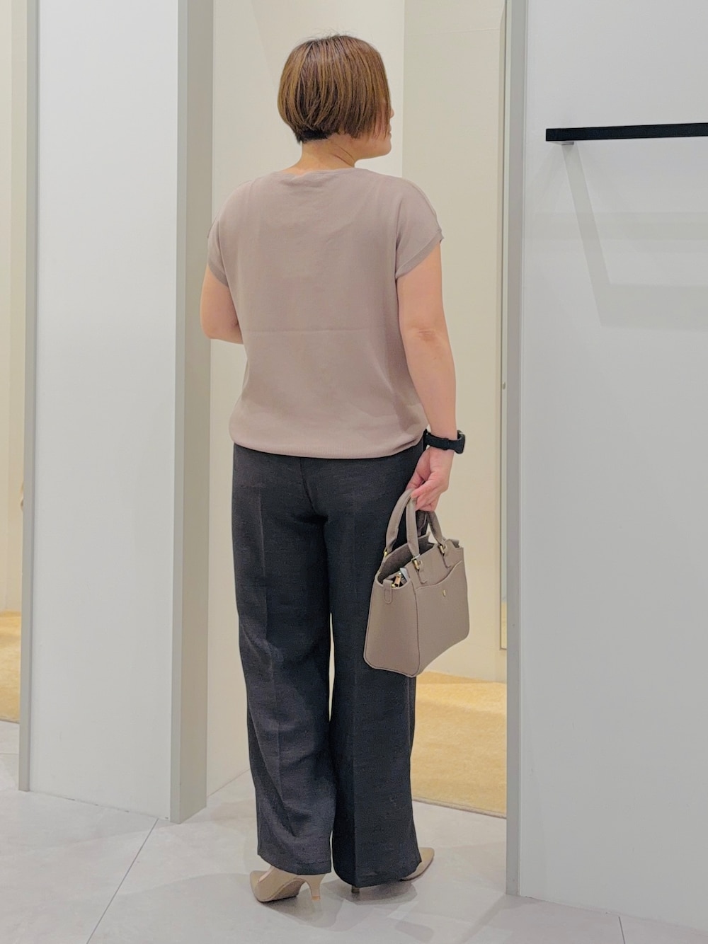 ベージュ系のニット/セーター、ブラック系のその他パンツ、ブラウン系のトートバッグを着用したレディースの夏コーディネートの4枚目の写真