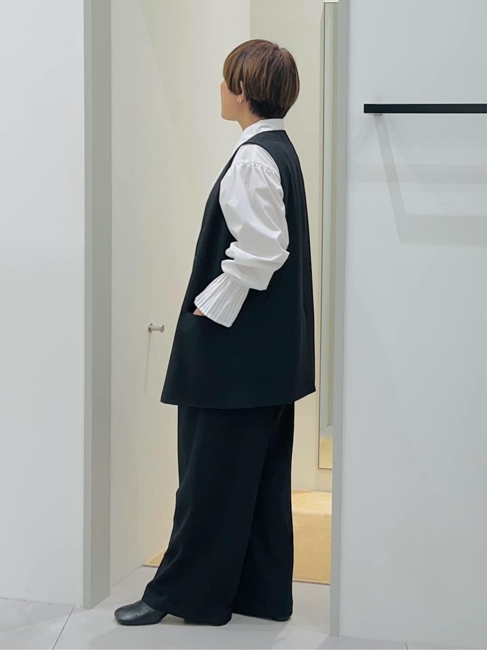 ブラック系のベスト、ホワイト系のシャツ/ブラウス、ブラック系のその他パンツを着用したレディースの秋コーディネートの3枚目の写真
