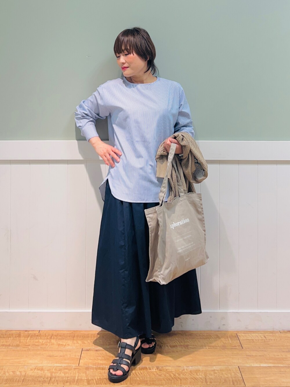 ブルー系のシャツ/ブラウス、ベージュ系のカーディガン/ボレロ、グレー系のトートバッグを着用したレディースの春コーディネートの3枚目の写真