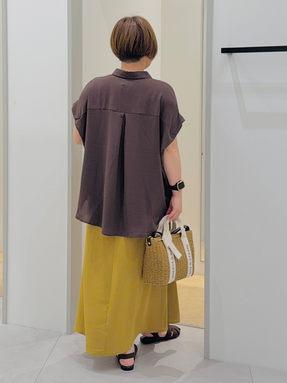 ブラウン系のシャツ/ブラウス、イエロー系のワンピース、ブラウン系のサンダルを着用したレディースの夏コーディネートの4枚目の写真