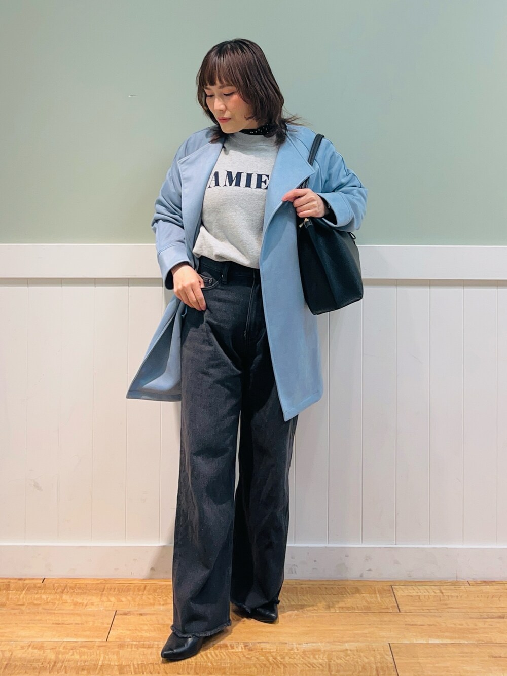 グレー系のニット/セーター、ブラック系のシャツ/ブラウス、ブルー系のノーカラーコートを着用したレディースの冬コーディネートの2枚目の写真