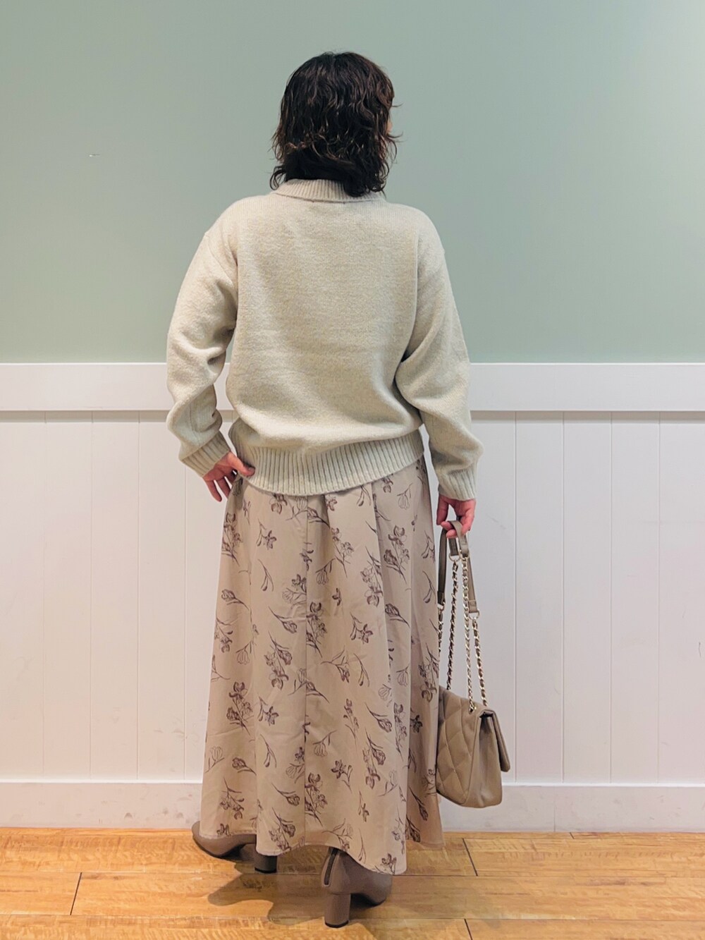 ベージュ系のニット/セーター、ベージュ系のショルダーバッグ、ベージュ系のスカートを着用したレディースの冬コーディネートの3枚目の写真