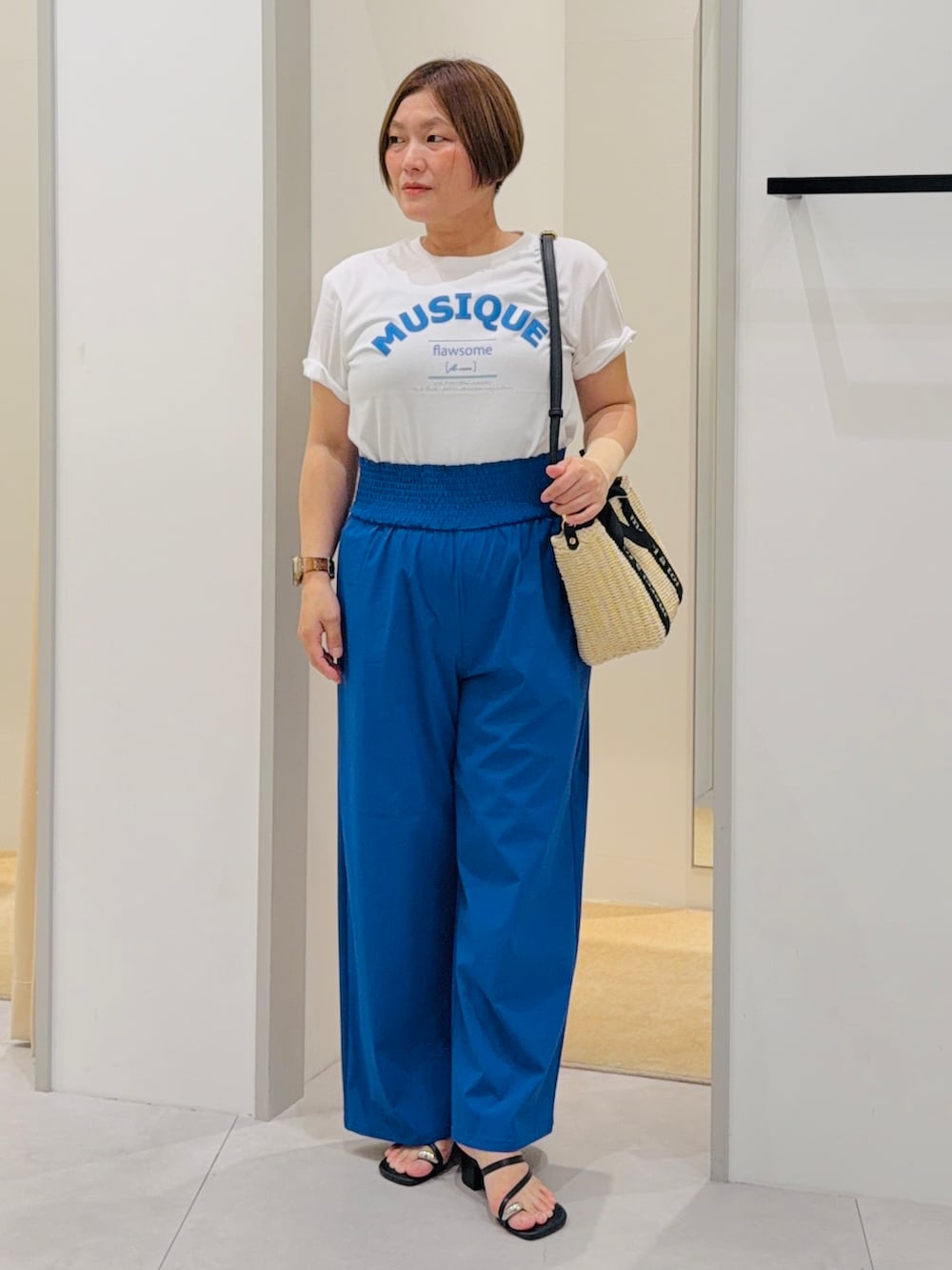 ホワイト系のTシャツ/カットソー、ブルー系のその他パンツ、ベージュ系のハンドバッグを着用したレディースの夏コーディネートの2枚目の写真