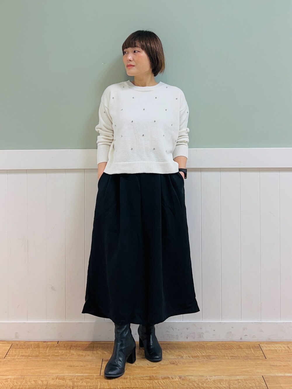 ブラック系のその他アウター、ホワイト系のニット/セーター、ブラック系のその他パンツを着用したレディースの冬コーディネートの4枚目の写真