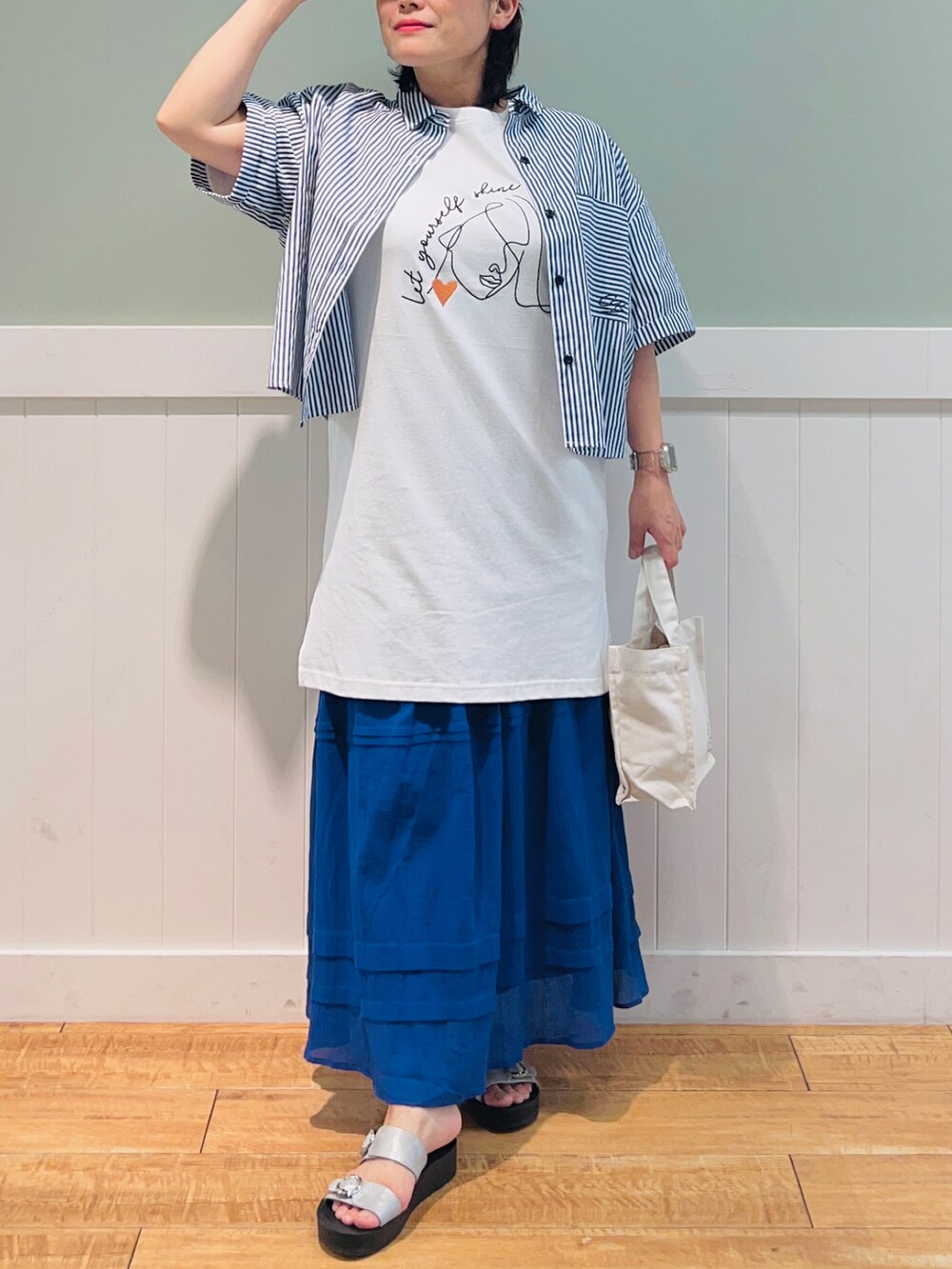 ブルー系のシャツ/ブラウス、ホワイト系のTシャツ/カットソー、ホワイト系のトートバッグを着用したレディースの夏コーディネートの4枚目の写真