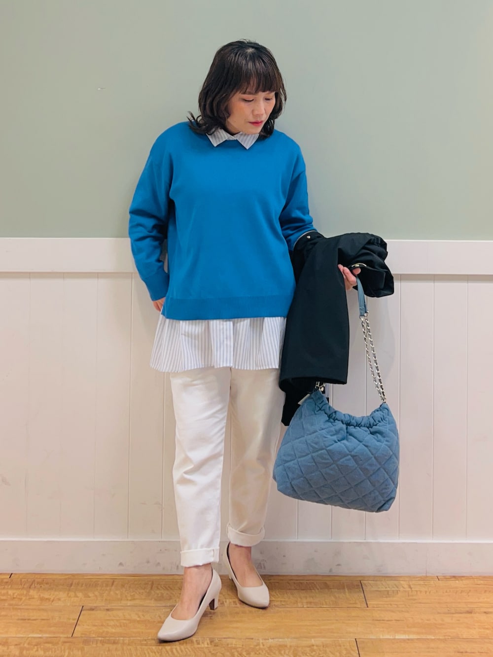 ブルー系のニット/セーター、ブラック系のその他アウター、ホワイト系のシャツ/ブラウスを着用したレディースの春コーディネートの3枚目の写真