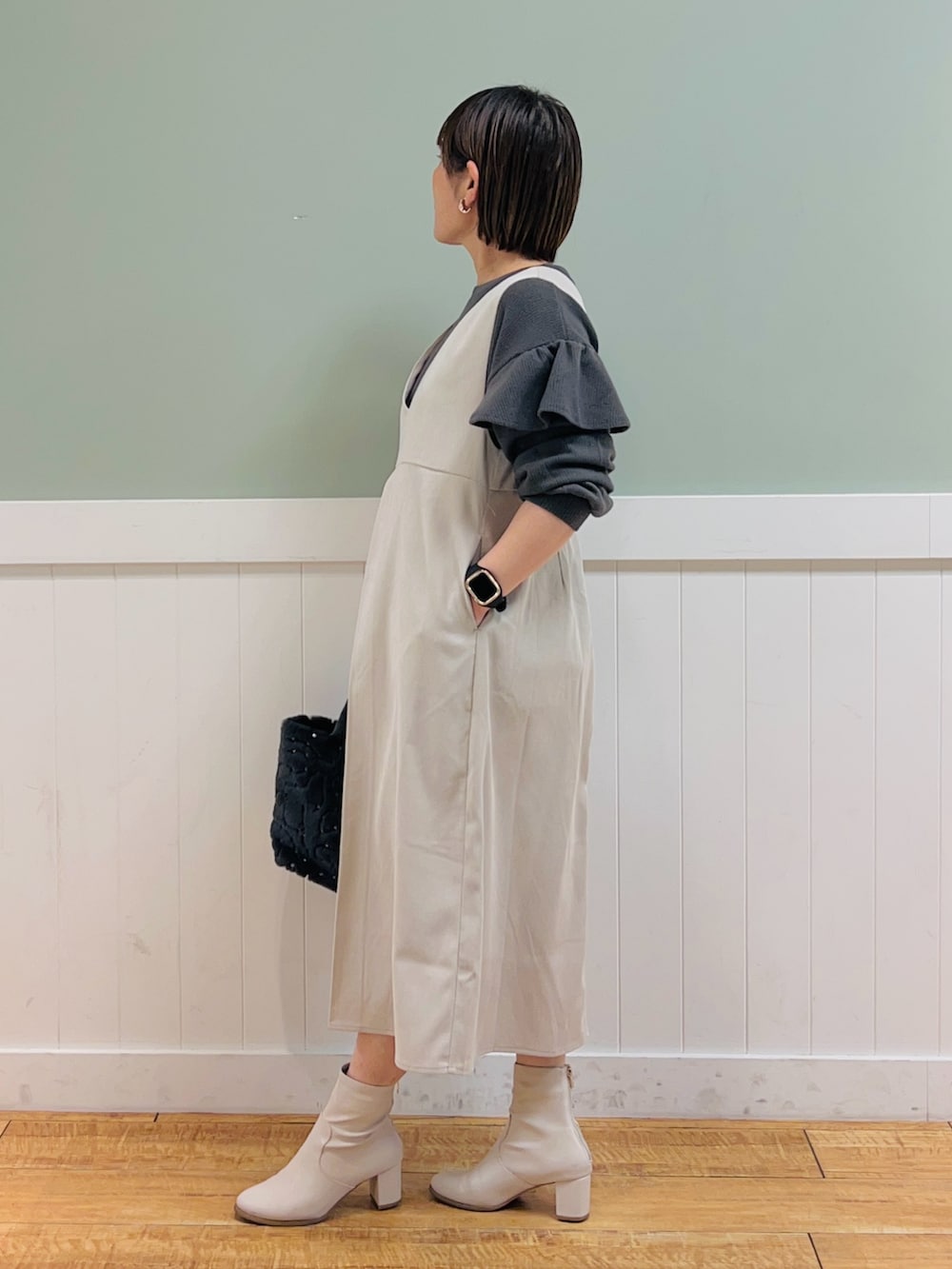 ベージュ系のワンピース、グレー系のTシャツ/カットソー、グレー系のトートバッグを着用したレディースの冬コーディネートの3枚目の写真