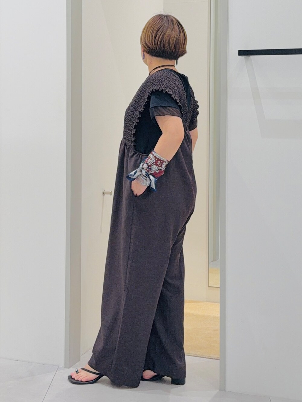 ブラウン系のサロペット/オーバーオール、ブラック系のTシャツ/カットソー、ブルー系のバンダナ/スカーフを着用したレディースの夏コーディネートの2枚目の写真