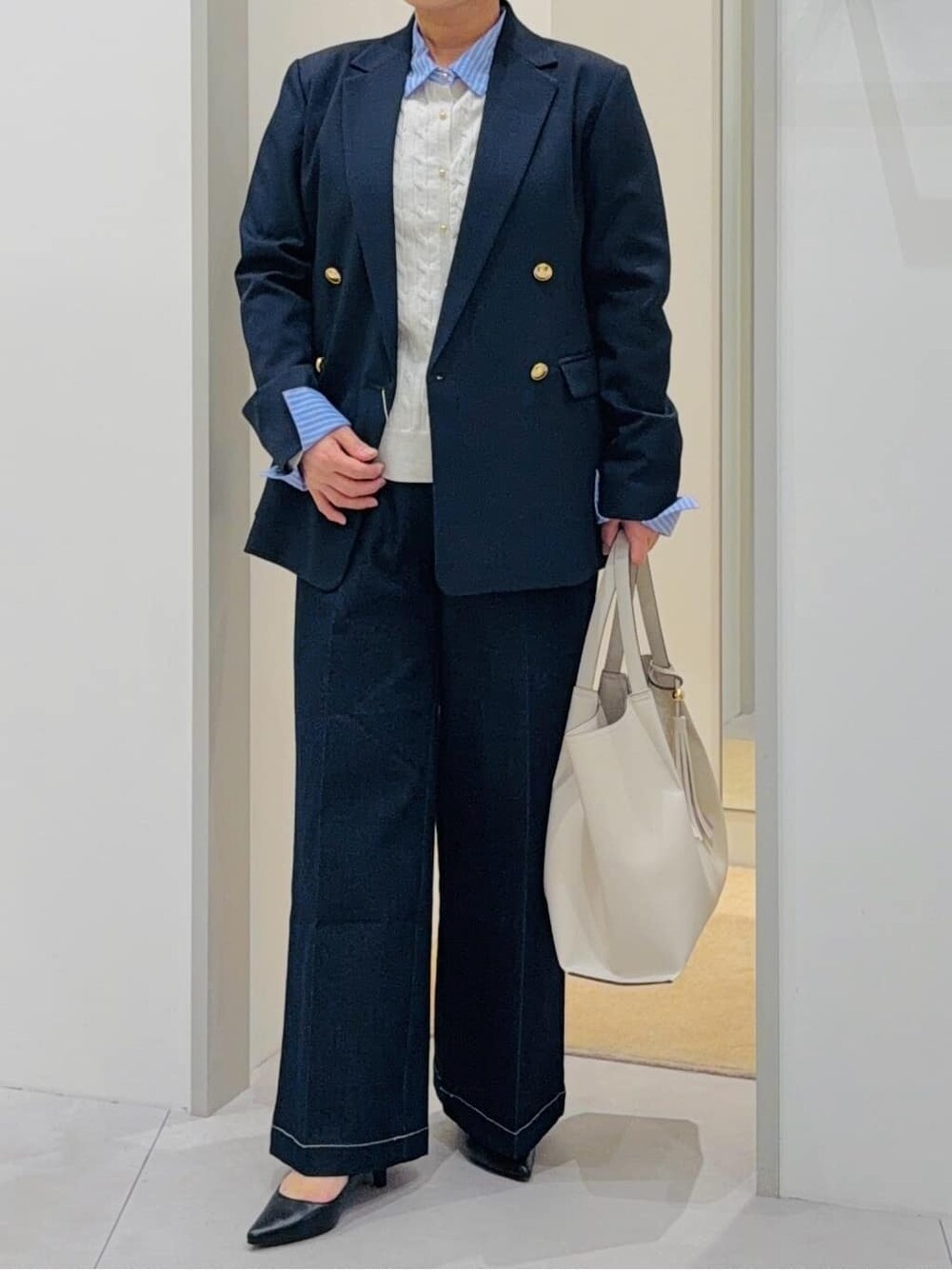 ブルー系のデニムパンツ、ホワイト系のTシャツ/カットソー、ホワイト系のトートバッグを着用したレディースの春コーディネートの4枚目の写真