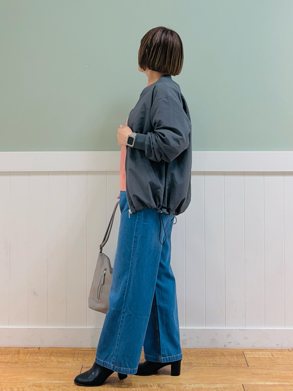 グレー系のブルゾン、ピンク系のニット/セーター、グレー系のショルダーバッグを着用したレディースの秋コーディネートの3枚目の写真