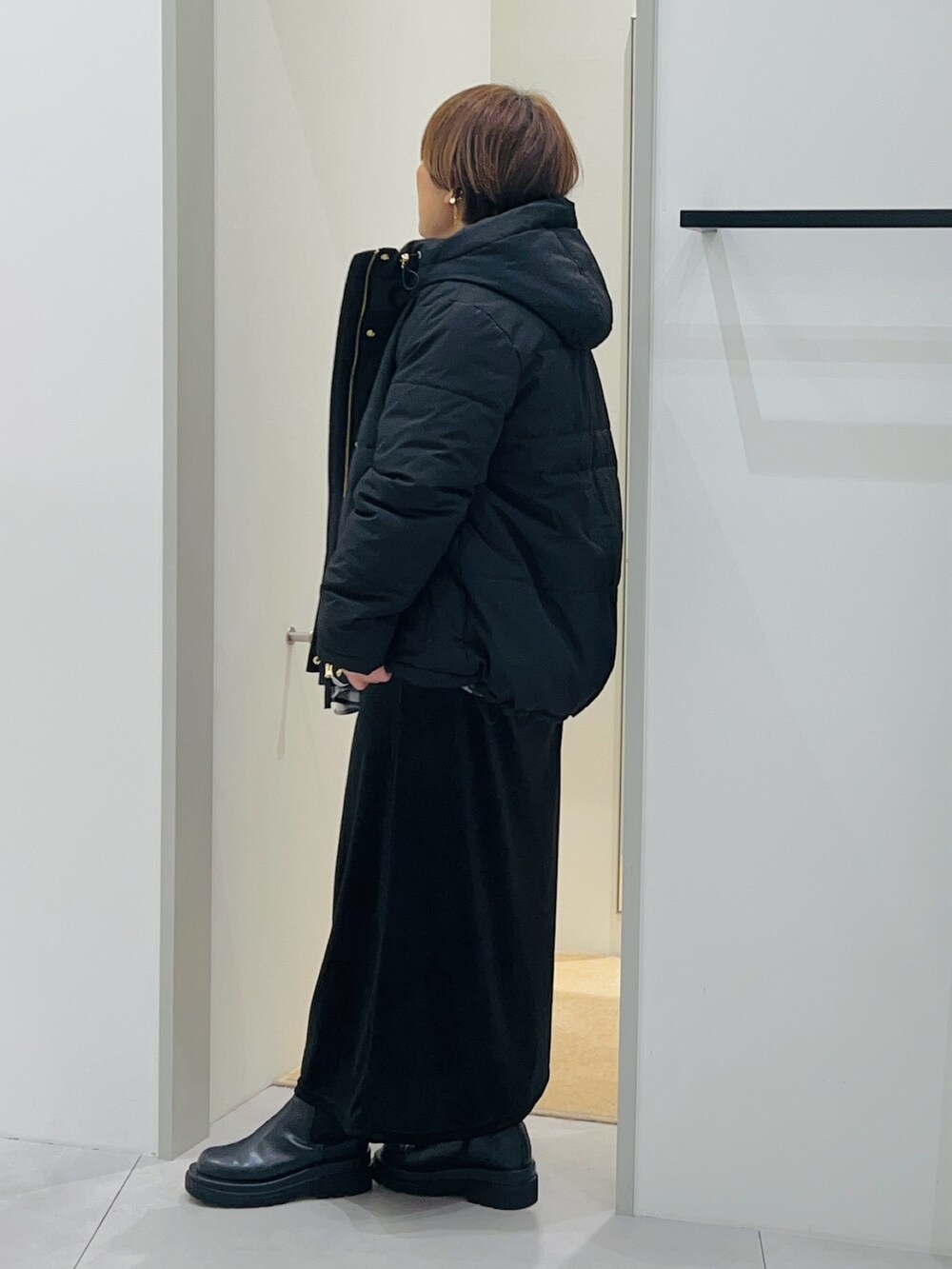 ブラック系のシャツ/ブラウス、ブラック系のスカート、ブラック系のブーツを着用したレディースの秋コーディネートの4枚目の写真