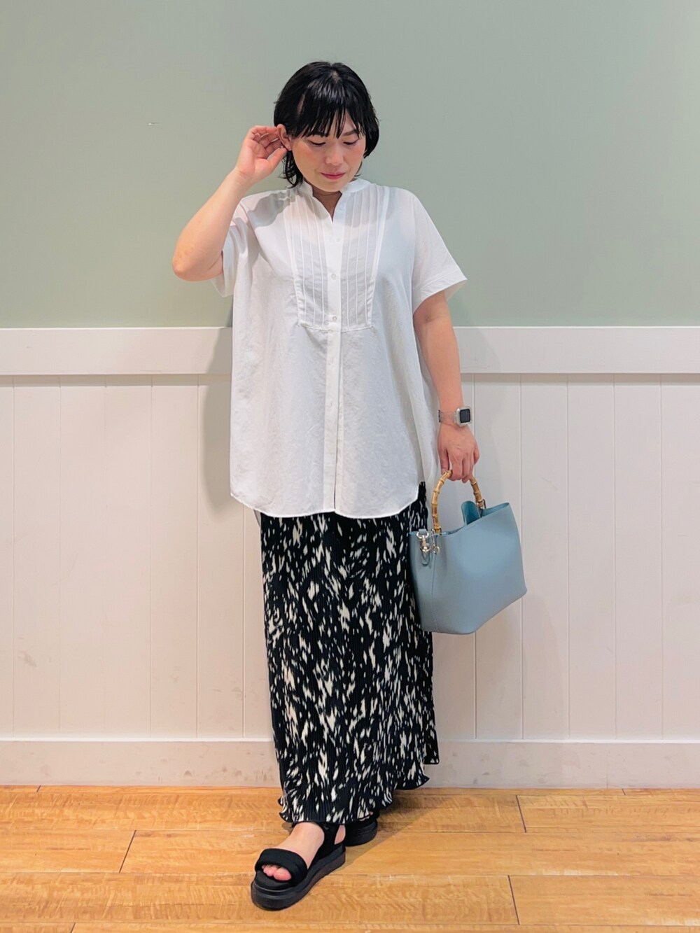 ホワイト系のシャツ/ブラウス、ブルー系のトートバッグ、ブラック系のスカートを着用したレディースの夏コーディネートの3枚目の写真