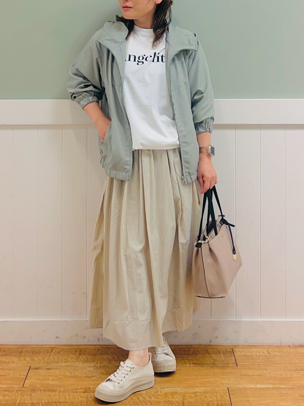 ホワイト系のTシャツ/カットソー、グリーン系のブルゾン、ベージュ系のスカートを着用したレディースの春コーディネートの4枚目の写真