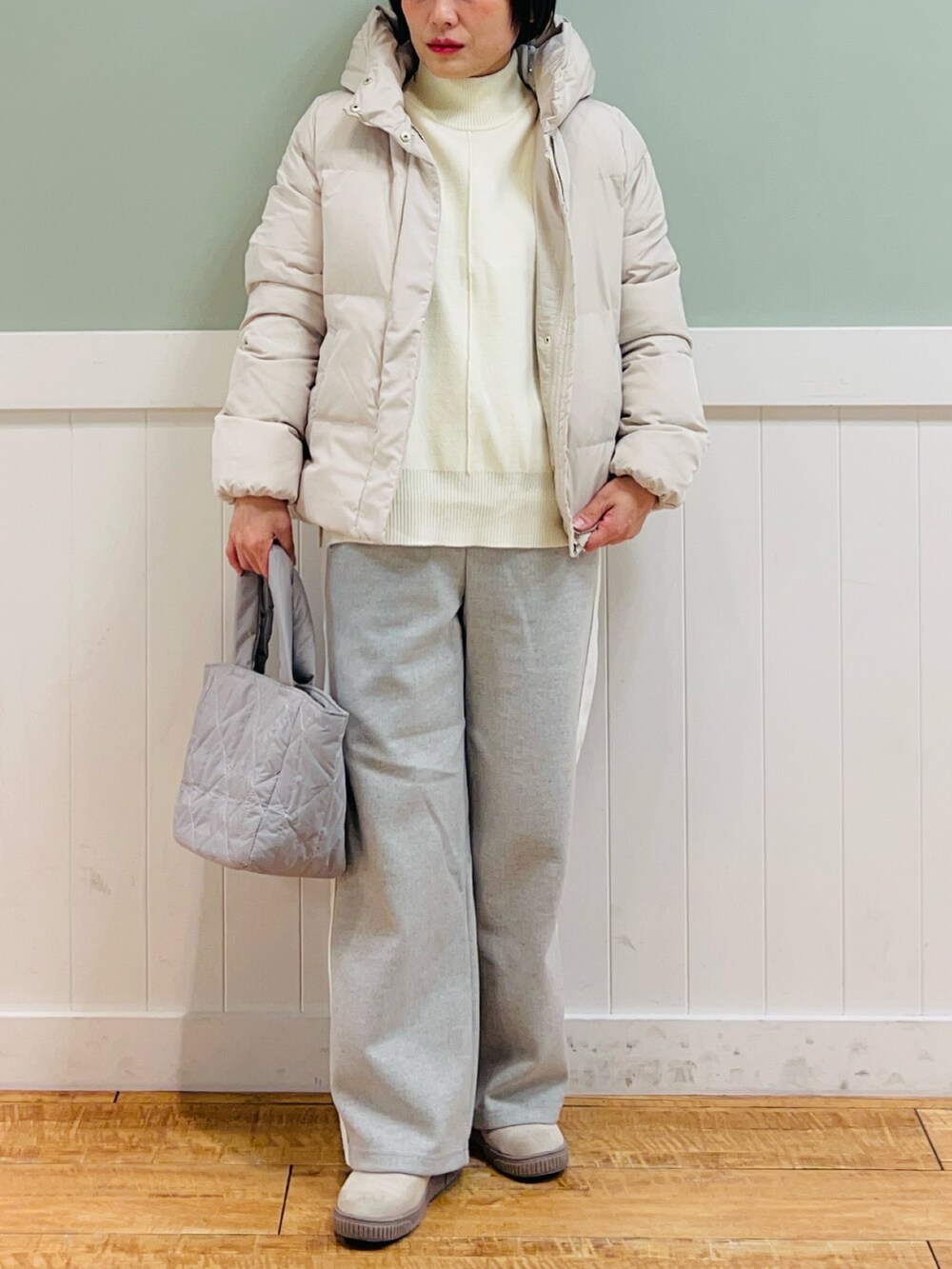 ベージュ系のダウンジャケット/コート、ホワイト系のニット/セーター、グレー系のその他パンツを着用したレディースの冬コーディネートの5枚目の写真