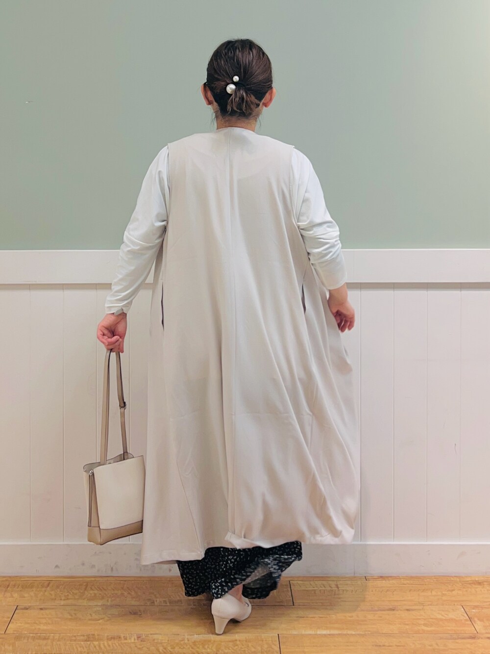 ベージュ系のベスト、ホワイト系のTシャツ/カットソー、ベージュ系のショルダーバッグを着用したレディースの春コーディネートの3枚目の写真