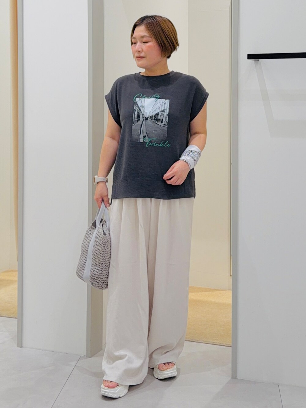 ブラック系のTシャツ/カットソー、ホワイト系のその他パンツ、グレー系のトートバッグを着用したレディースの夏コーディネートの2枚目の写真