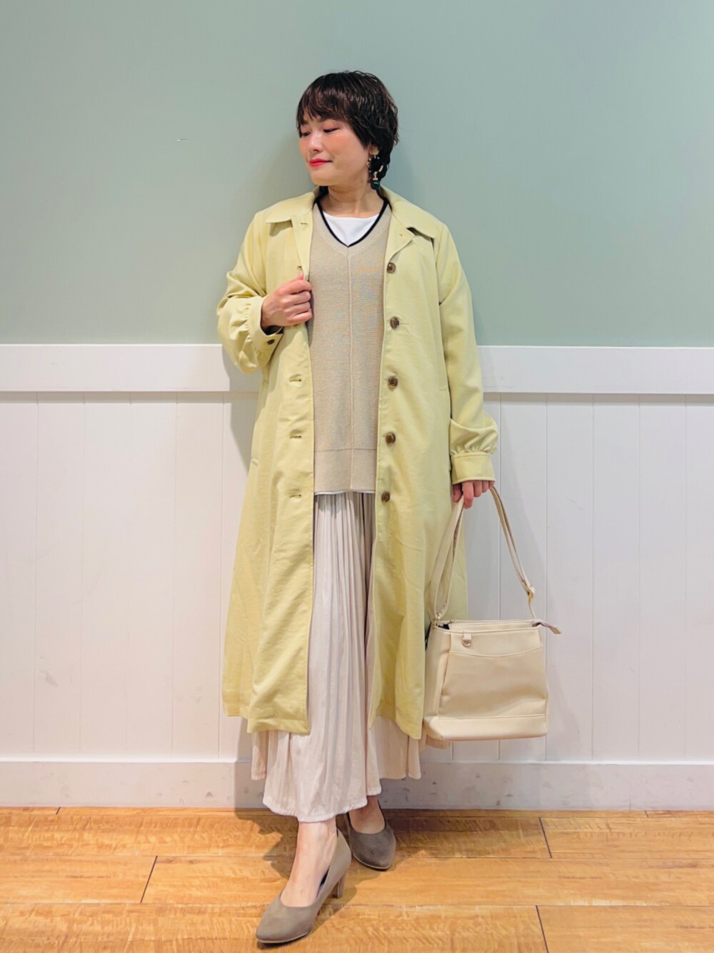 ベージュ系のその他トップス、イエロー系のステンカラーコート、ベージュ系のスカートを着用したレディースの春コーディネートの4枚目の写真