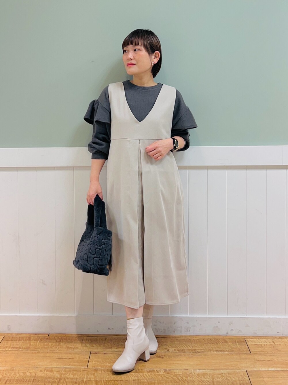 ベージュ系のワンピース、グレー系のTシャツ/カットソー、グレー系のトートバッグを着用したレディースの冬コーディネートの2枚目の写真