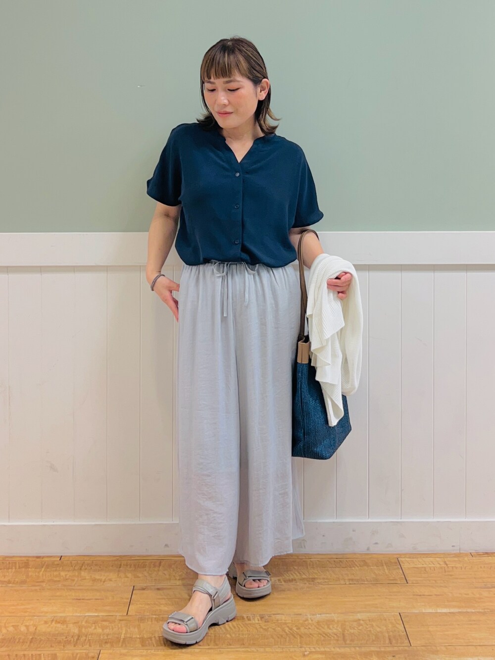 ブルー系のシャツ/ブラウス、ホワイト系のカーディガン/ボレロ、グレー系のその他パンツを着用したレディースの夏コーディネートの3枚目の写真