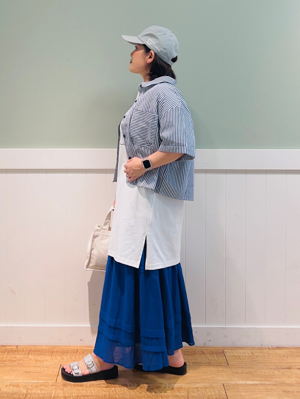 ブルー系のシャツ/ブラウス、ホワイト系のTシャツ/カットソー、ホワイト系のトートバッグを着用したレディースの夏コーディネートの2枚目の写真