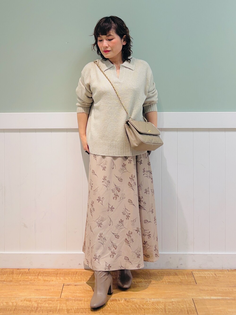 ベージュ系のニット/セーター、ベージュ系のショルダーバッグ、ベージュ系のスカートを着用したレディースの冬コーディネートの4枚目の写真