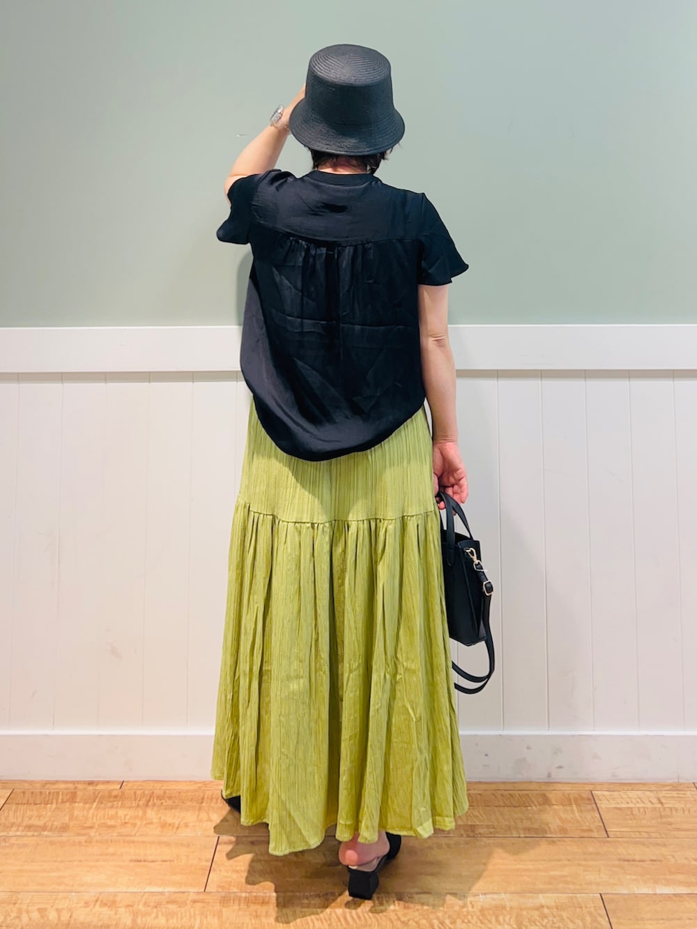 ブラック系のシャツ/ブラウス、ブラック系のショルダーバッグ、グリーン系のスカートを着用したレディースの春コーディネートの2枚目の写真