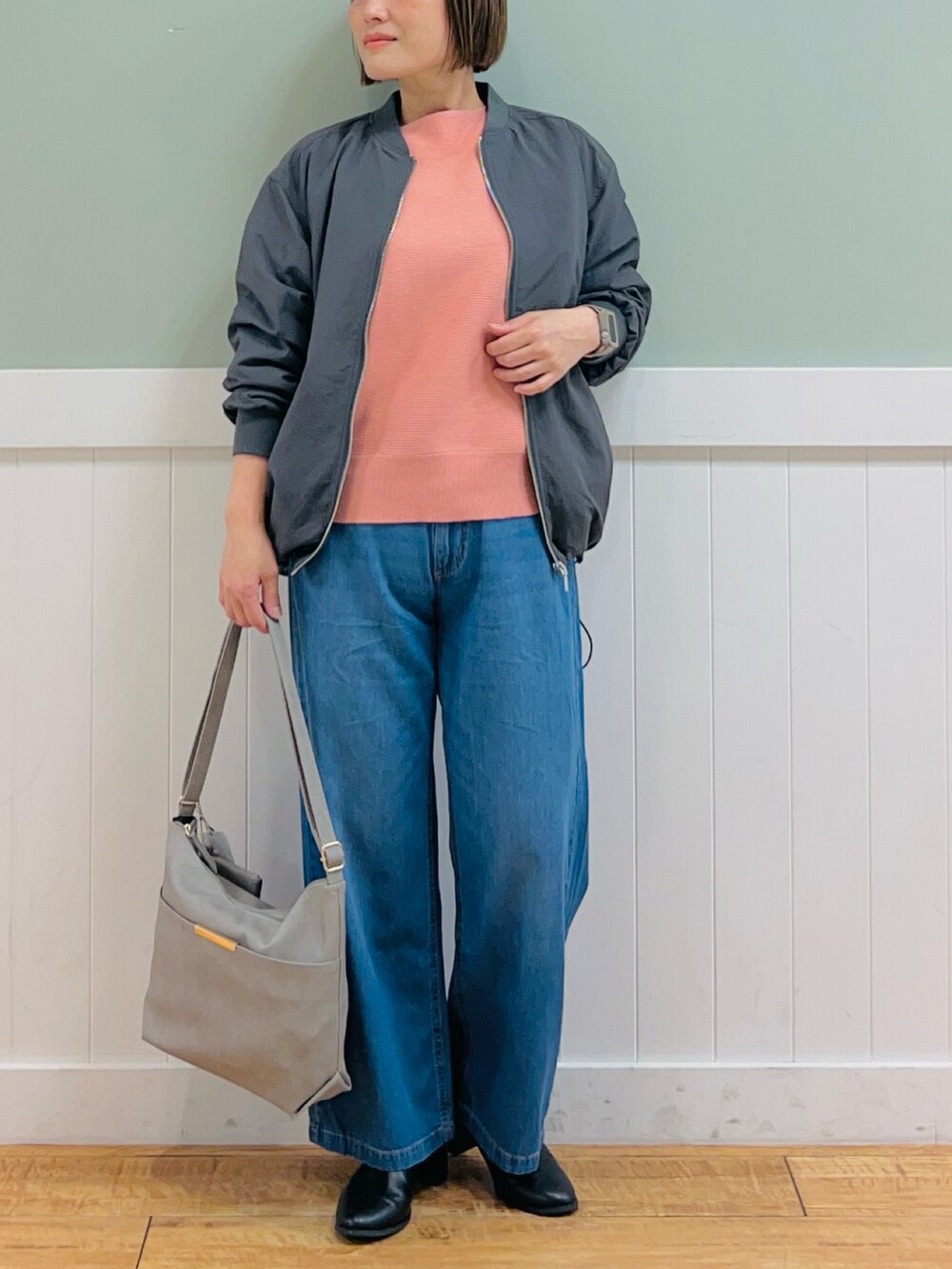 グレー系のブルゾン、ピンク系のニット/セーター、グレー系のショルダーバッグを着用したレディースの秋コーディネートの5枚目の写真