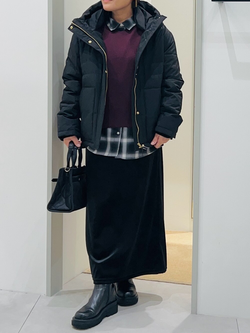 ブラック系のシャツ/ブラウス、ブラック系のスカート、ブラック系のブーツを着用したレディースの秋コーディネートの6枚目の写真