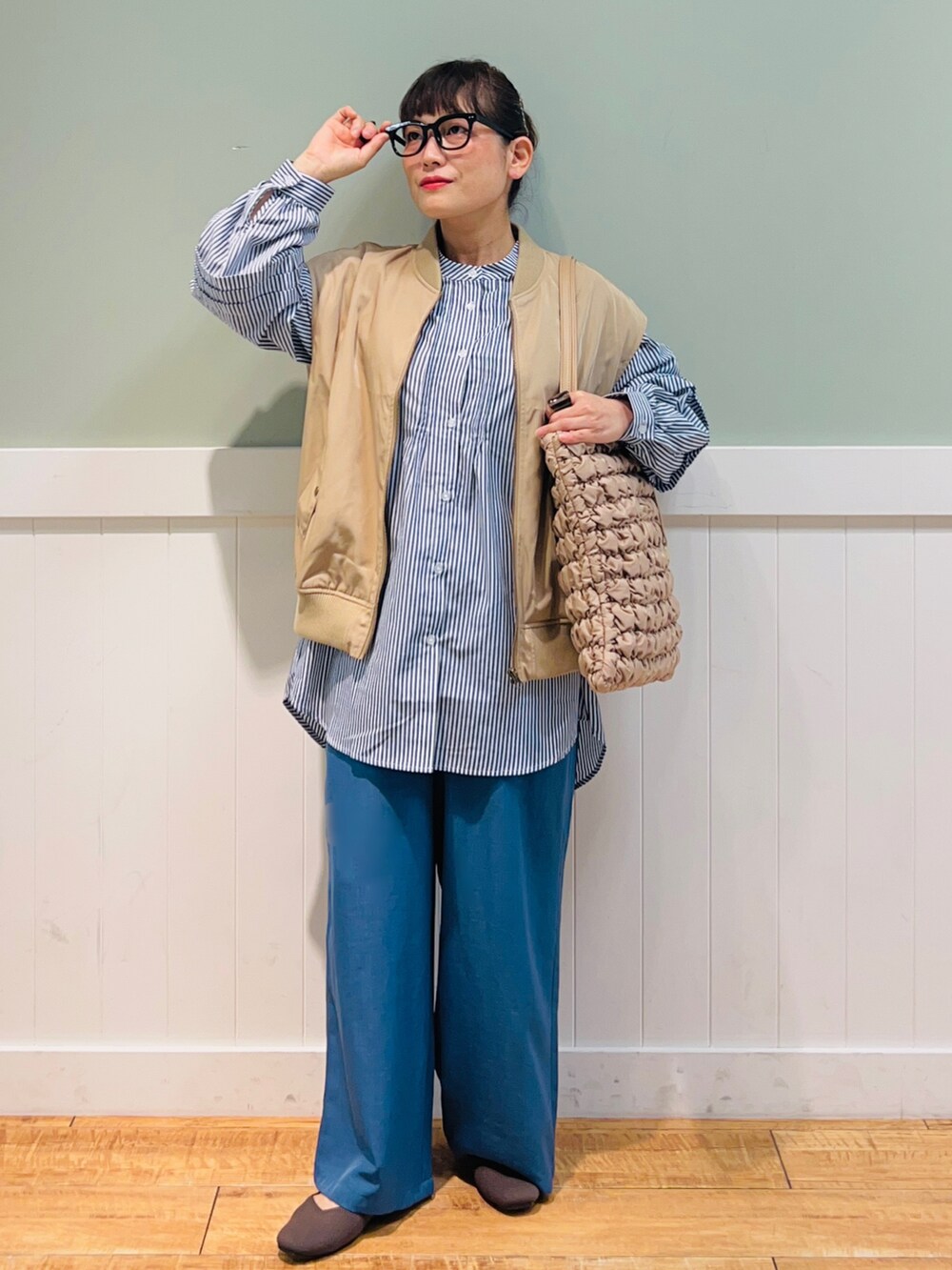 ブルー系のシャツ/ブラウス、ブラウン系のベスト、ベージュ系のバッグを着用したレディースの秋コーディネートの5枚目の写真