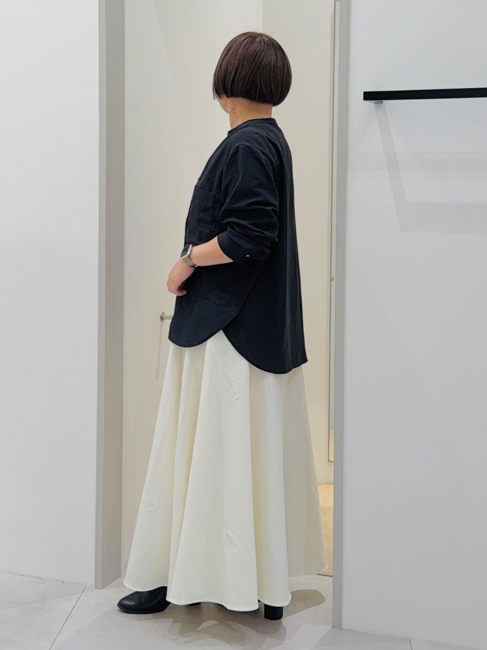 ブラック系のシャツ/ブラウス、ホワイト系のスカート、レッド系のショルダーバッグを着用したレディースの秋コーディネートの3枚目の写真