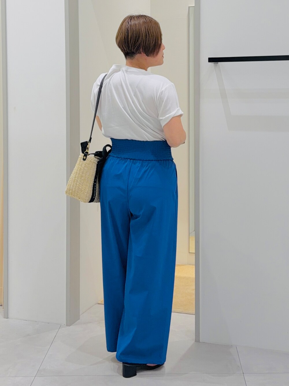 ホワイト系のTシャツ/カットソー、ブルー系のその他パンツ、ベージュ系のハンドバッグを着用したレディースの夏コーディネートの4枚目の写真