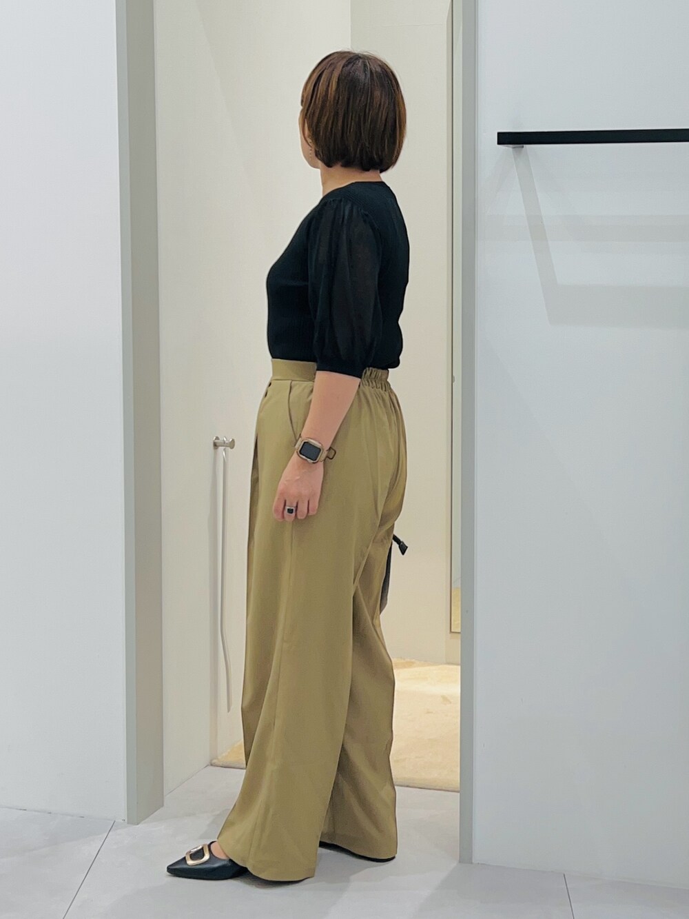 ブラック系のニット/セーター、ベージュ系のその他パンツ、ブラック系のショルダーバッグを着用したレディースの秋コーディネートの2枚目の写真