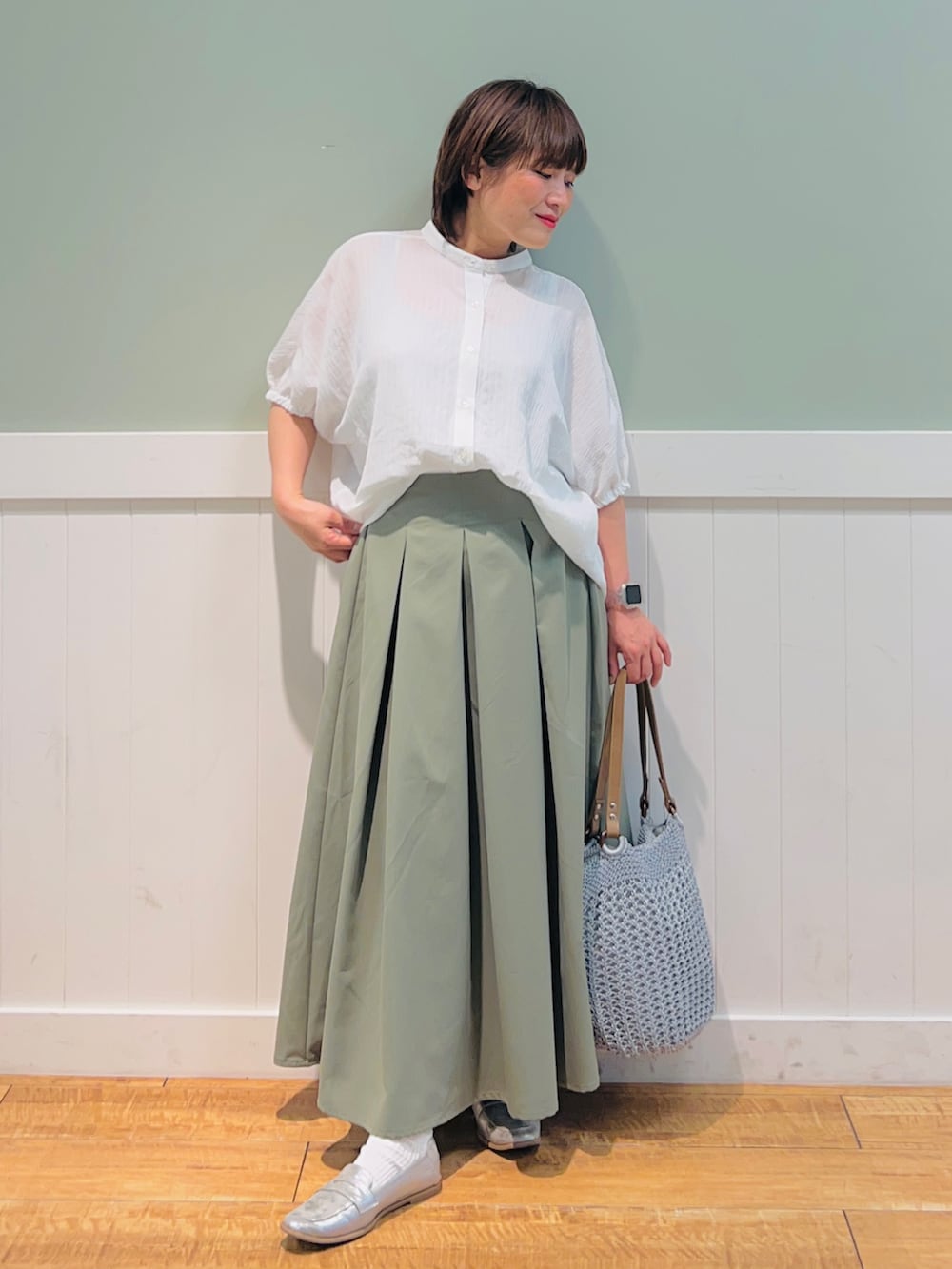 ホワイト系のシャツ/ブラウス、グリーン系のスカート、グレー系のトートバッグを着用したレディースの春コーディネートの3枚目の写真