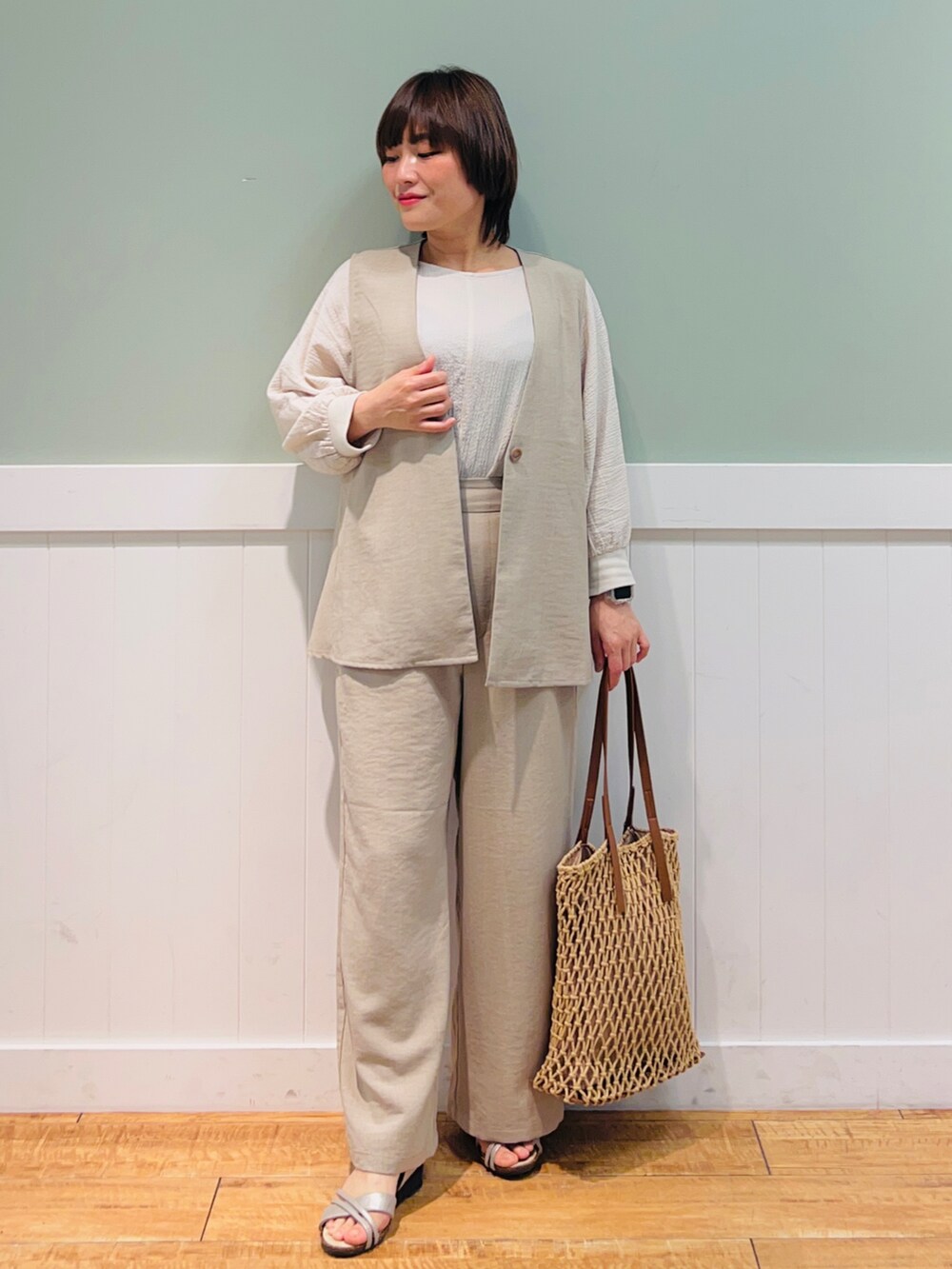 ベージュ系のベスト、ブラウン系のトートバッグ、ベージュ系のシャツ/ブラウスを着用したレディースの春コーディネートの4枚目の写真