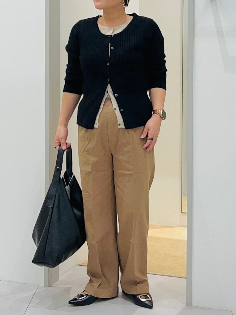ブラック系のニット/セーター、ベージュ系のその他パンツ、ブラック系のトートバッグを着用したレディースの秋コーディネートの5枚目の写真