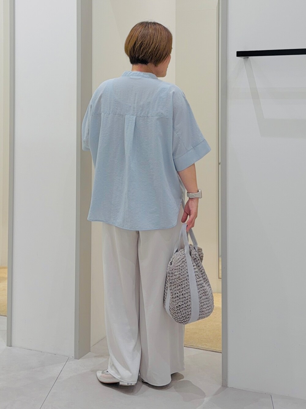 ブルー系のシャツ/ブラウス、ホワイト系のその他パンツ、グレー系のトートバッグを着用したレディースの夏コーディネートの4枚目の写真