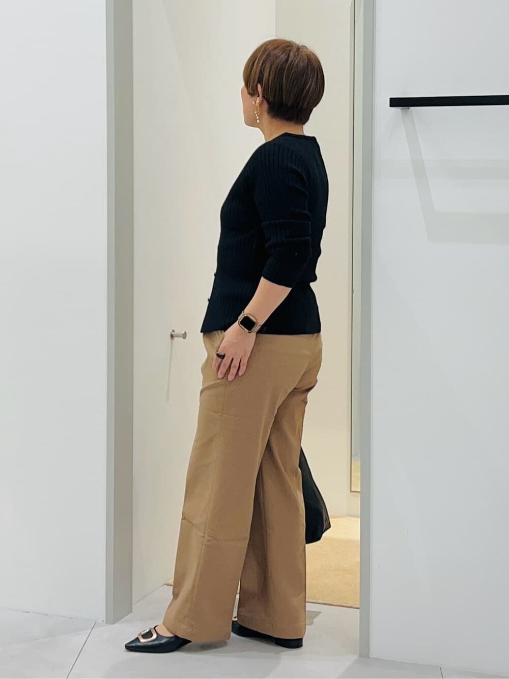 ブラック系のニット/セーター、ベージュ系のその他パンツ、ブラック系のトートバッグを着用したレディースの秋コーディネートの3枚目の写真
