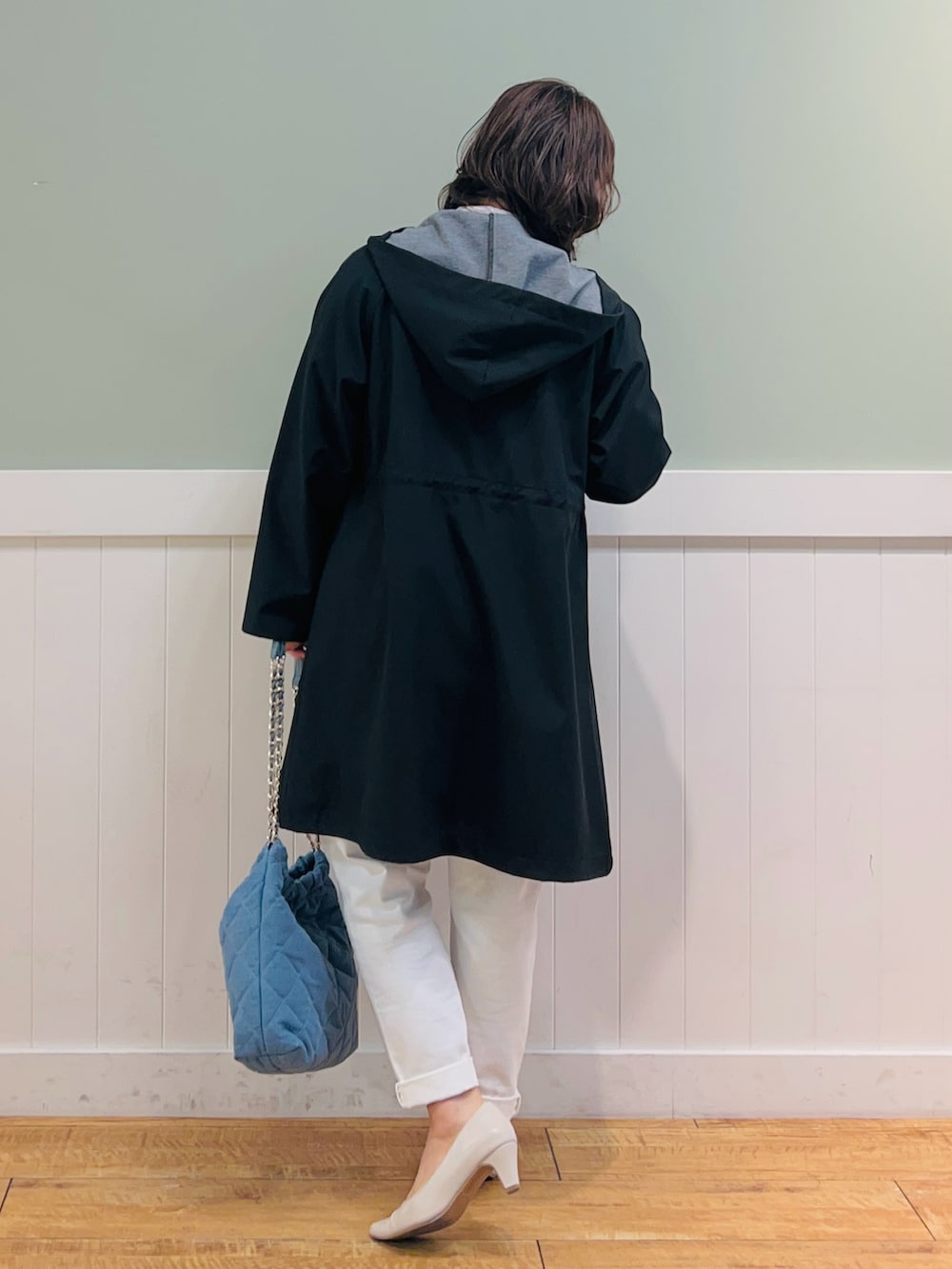 ブルー系のニット/セーター、ブラック系のその他アウター、ホワイト系のシャツ/ブラウスを着用したレディースの春コーディネートの2枚目の写真